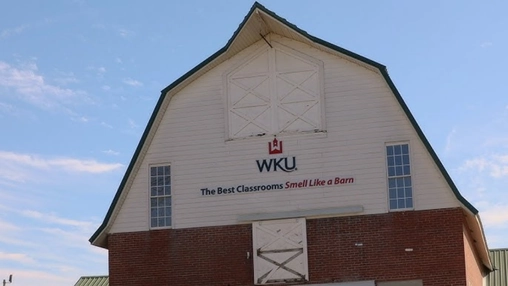 WKU barn-style agricultural building with slogan promoting hands-on dairy technology learning.