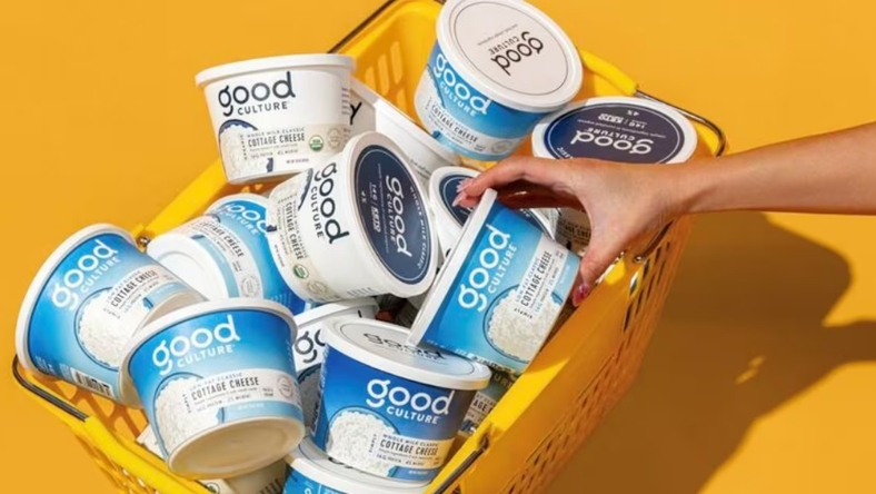 Hand picking Good Culture cottage cheese from yellow basket